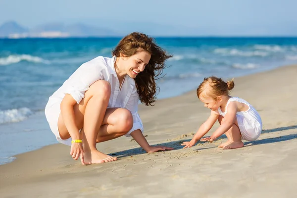 Mother and daughter playing on the beach — Stock Photo, Image