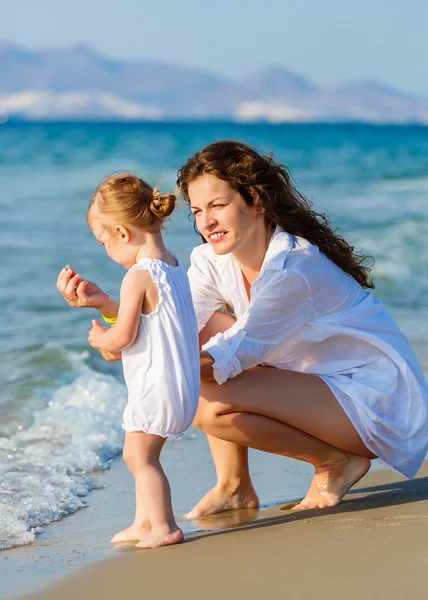 Mor och dotter leker på stranden — Stockfoto