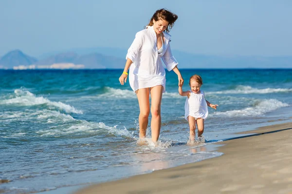 Matka a dcera běží na pláži — Stock fotografie