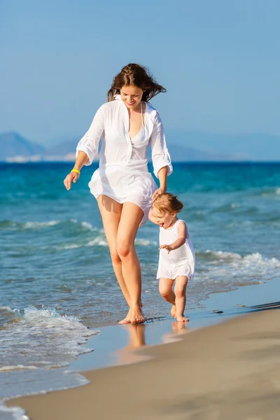 Mother and daughter walking on the beach — Stock Photo, Image