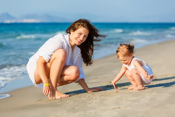 Mor och dotter leker på stranden — Stockfoto