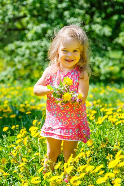 Liten flicka med bukett i parken — Stockfoto