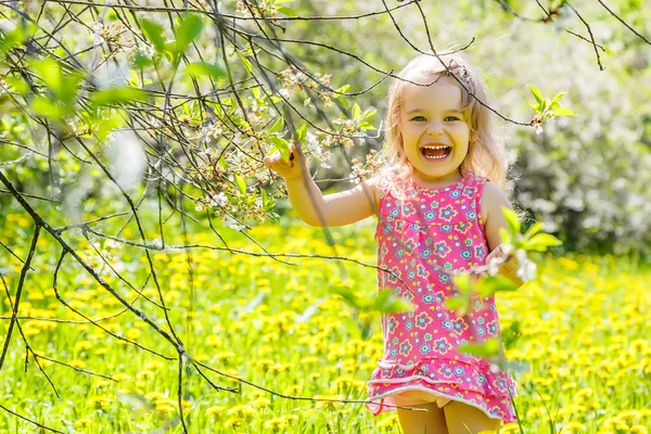 Ευτυχισμένο κοριτσάκι στο ηλιόλουστο πάρκο της άνοιξης — Φωτογραφία Αρχείου