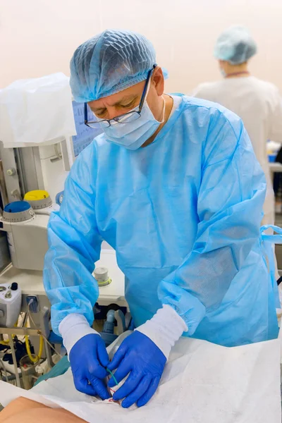 Doctor inserts double lumen catheter in jugular vein in operation room