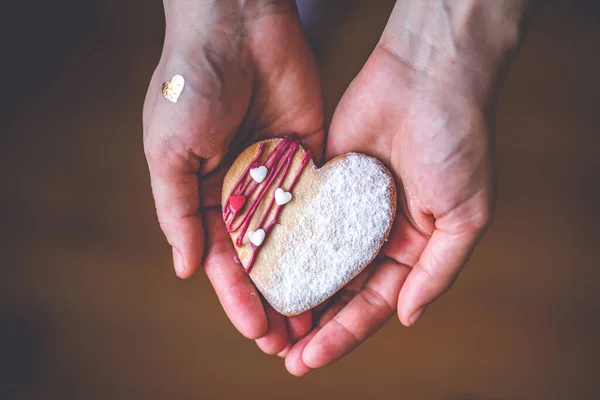 Kadın elleri elinde tatlı kalp pastası tutuyor. Aşkın sembolü