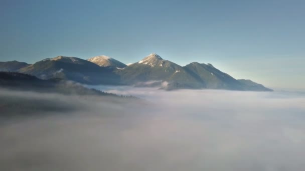 Voe acima de nuvens nebulosas em montanhas ensolaradas — Vídeo de Stock