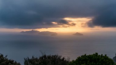 Okyanus ve küçük ada üzerinde hızlı hareket eden dramatik bulutlar Zaman kayması