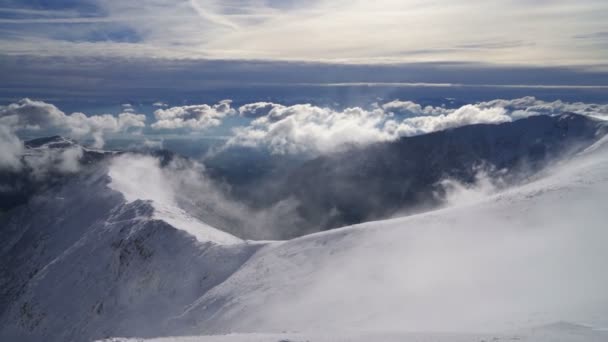 Vacker utsikt från snöiga alpina berg i solig vinter över molnen — Stockvideo