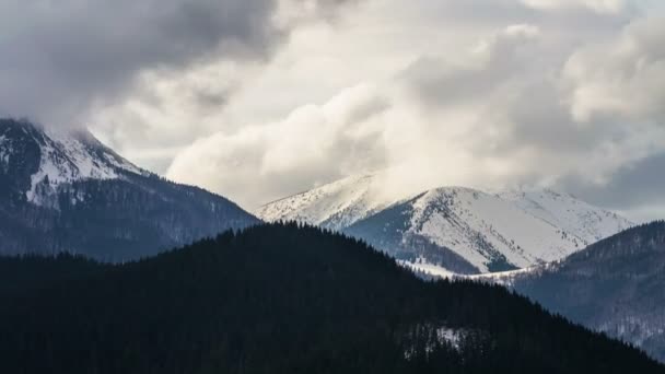 Dramatiska moln rör sig över snöiga alpina berg i kall vinter Time lapse — Stockvideo