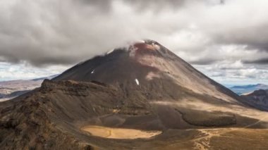 Tongariro Ulusal Parkı 'ndaki volkanik Doom Dağı' nın tepesindeki dramatik gri bulutlar Yeni Zelanda Zaman atlaması yaşıyor.