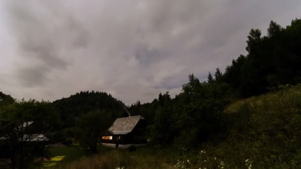 Nuvens movendo-se rápido no céu à noite sobre casa de férias em montanhas da floresta natureza lapso de tempo — Vídeo de Stock