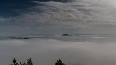Dolunayın altındaki bir vadide hızla ilerleyen sisli bulutların atmosferik zaman atlaması. Parlak ay ışığı gece gökyüzünü delip geçerek gizemli ve sinematik bir gece manzarası yaratır..