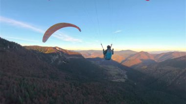İki paraşütçü, bir sonbahar ormanının üzerinde sakince süzülür, düzgün bir takip kamerasıyla yakalanır. Adrenalin, özgürlük ve huzurlu yamaç paraşütü karışımı güzel mevsimsel bir manzara.. 