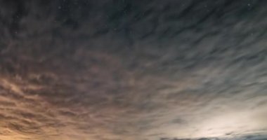 Çarpıcı astronomi zaman atlaması, parlak Samanyolu galaksisini yıldızlı bir gecede ortaya çıkarmak için hızla uzaklaşan bulutları gösteriyor. Barışçıl ve büyüleyici göksel bir arka plan..