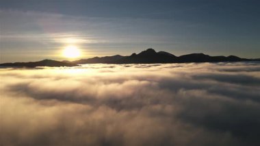 Altın gün doğumunda sisli bulutların üzerinde rüya gibi bir uçuş. Ilık bir sabah güneşi, sakin bir atmosfer ve cennet manzarası barışçıl ve ilham verici bir doğa yaratıyor.