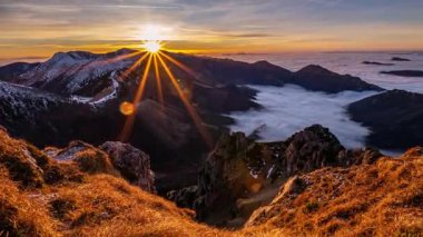 İlkbaharın başlarında, son karlı dağlarda güzel bir gün batımı. Altın güneş ışığı kuru alp çayırlarını aydınlatır ve sisli bulutlar vadiden bir nehir gibi akar, sakin, huzurlu ve...