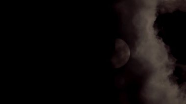 Güneş tutulması sırasında kara fırtınalı bulutların arkasından yükselen güneş tutulması. Dramatik doğal ışıklandırma, astronomi ve hava durumu için mükemmel güçlü ve atmosferik bir gökyüzü sahnesi yaratır.