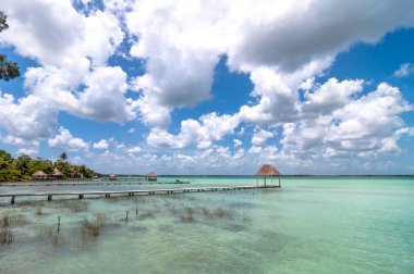 Idyllic pier and palapa hut in Bacalar lagoon in Mexico clipart