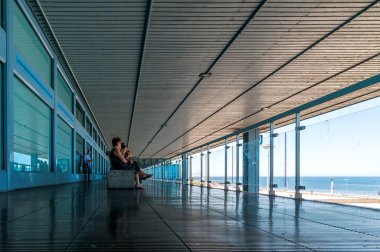 açık teras havaalanında bekleyen yolcular silüeti