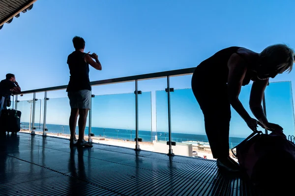 Silhouette von Passagieren, die auf offener Terrasse im Flughafen warten — Stockfoto