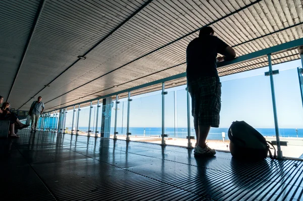 Silhuett av passagerare väntar på öppen terrass i flygplats — Stockfoto