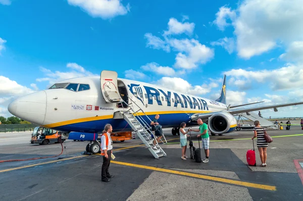 승객은 이탈리아 피사 공항에 도착 후 Ryanair 제트 비행기를 비행기에서 내리 다 — 스톡 사진