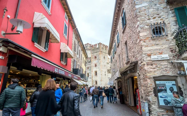 Gadeudsigt med butikker og turister i Sirmione, Italien - Stock-foto