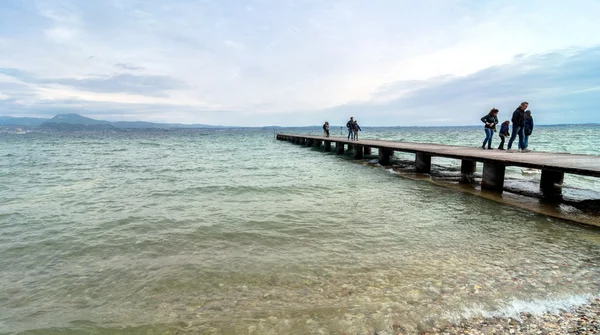 Muelle de madera y cielo sobre el lago de Garda - Italia — Foto de Stock