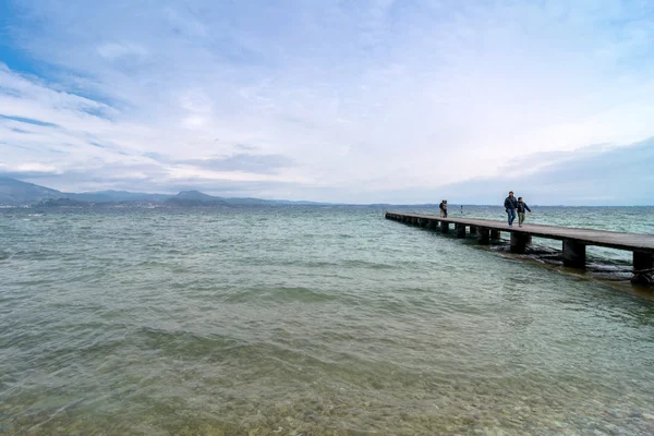 Muelle de madera y cielo sobre el lago de Garda - Italia — Foto de Stock