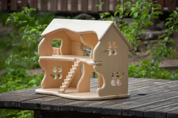 Wooden handcrafted two-story doll house. Waldorf handmade play thing for kids. Natural material toys outdoor