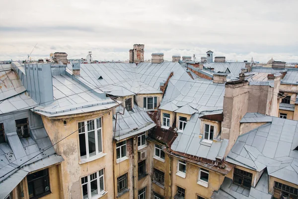Iron roofs of houses in old city on cloudy day. Top view of houses of St. Petersburg.