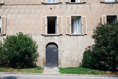 Bir İtalyan şehrinde eski bir evin giriş kapısı ve pencereleriyle ön cephe.