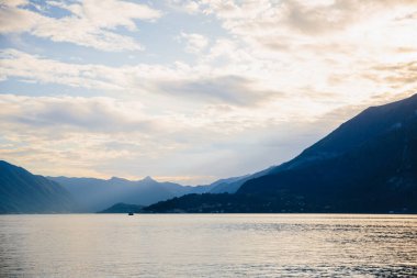 Gün batımında manzara. Dağlarla, vadilerle çevrili mavi göl.