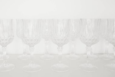 Bulaşıklar mutfakta. Şeffaf cam şarap kadehleri, mutfak dolabındaki beyaz rafta sıra olun..