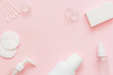 Cilt bakım modeli. Güzellik konsepti. Cilt bakım ürünleri, şişeler, sprey, pamuk pedler ve pembe arka planda sabun. Metin için boş alan.