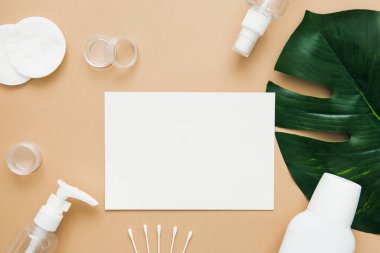 Cilt bakımı şablonu. Doğal cilt bakım ürünleri, şişeler, pamuk pedler ve bej arka planda sabun. Metin için boş alan, kopyalama alanı.