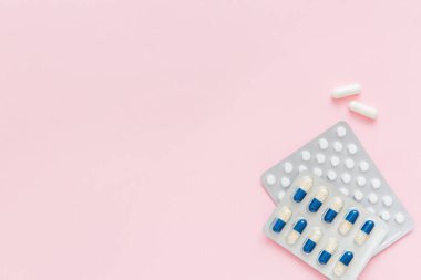 Pembe arka planda ilaç içeren beyaz haplar ve kapsüller. Kadın Sağlığı. Hastalık önleme. Boşluğu kopyala.