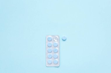 Erkek sağlığı. Açık mavi arka planda yuvarlak mavi haplarla su toplamış. İlaç alıyorum. Hastalık tedavisine başlayın.