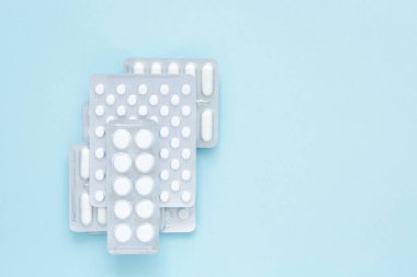 Mavi arka planda beyaz hapların kabarcıkları, üst manzara. Çeşitli ilaç ürünleri, haplar, ilaç kapsülleri. Tedavi konsepti. Boşluğu kopyala.