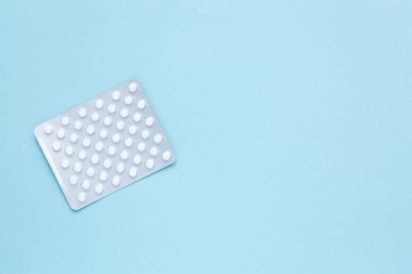 Sağlık hizmeti konsepti. Mavi arka planda beyaz haplı su toplayıcı paketi. Boşluğu kopyala.