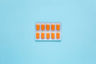 Mavi arka planda ilaçlı su toplayıcısı paketi, üst manzara. Beslenme takviyeleri, sağlık ve vücut tonu için vitaminler. İyi ruh hali kavramı.