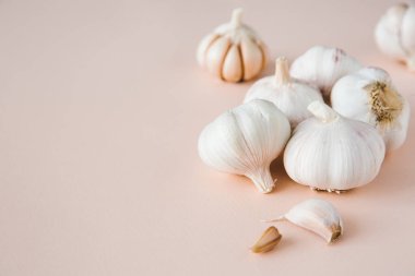 Pembe arka planda soğan ve karanfil sarımsağı, yakın plan. Organik sarımsak. Boşluğu kopyala.