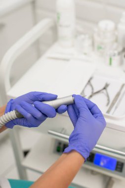 Pedikür ustası çivi işlemek için cihaza yeni bir kesici yerleştirdi