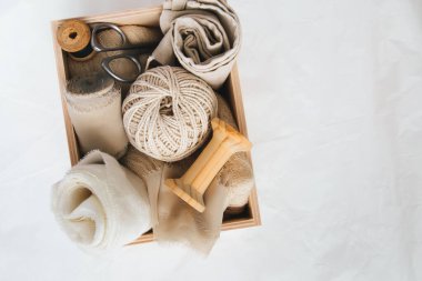 Dikiş ve dikiş işi için aksesuarlarla dolu bir kutu: iplikler, kumaşlar, makas. Dikiş ve dikiş konsepti. 