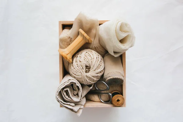 Box with accessories for sewing and needlework: threads, fabrics, scissors. Sewing and needlework concept.