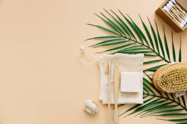 Çevre dostu banyo aksesuarları: bambu diş fırçaları, bambu kulak çubukları, organik sabun, bej arka planda yeniden kullanılabilir pamuk torbaları. Sıfır atık. Atık olmayan hayat.