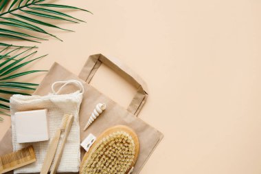 Çevre dostu banyo aksesuarları: bambu diş fırçaları, bambu kulak çubukları, organik sabun, bej arka planda yeniden kullanılabilir pamuk torbaları. Sorumlu tüketim konsepti. Spa, cilt bakımı. Boşluğu kopyala.