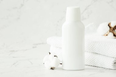 Banyodaki rafta boş beyaz kozmetik kap, kavanoz ve havlular var. Yüz ve vücut bakımı için kozmetik ürünleri. Boşluğu kopyala.