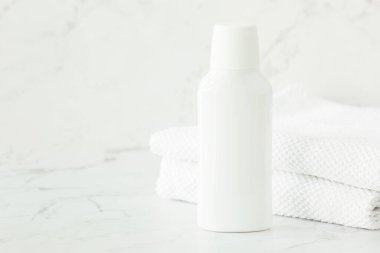 Banyodaki rafta boş beyaz kozmetik kap, kavanoz ve havlular var. Yüz ve vücut bakımı için kozmetik ürünleri. Boşluğu kopyala.