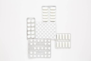 Beyaz arka planda beyaz hapların kabarcıkları, üst manzara. Çeşitli ilaçlar, haplar, ilaç kapsülleri. Tedavi kavramı.